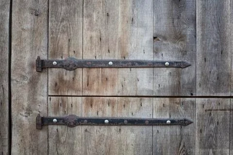 Old wooden massive opened gate. Double door with iron handles and hinges Stock Photos
