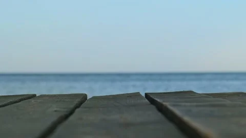 An old wooden pier in close-up against the background of a blurred blue sea and Stock Footage 163742653