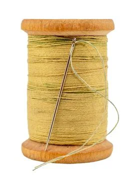 An old wooden spool of thread and a needle on a white background close-up. Th Stock Photos