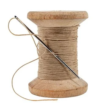 Old wooden spool of thread and needle on a white background. Sewing accessori Stock Photos