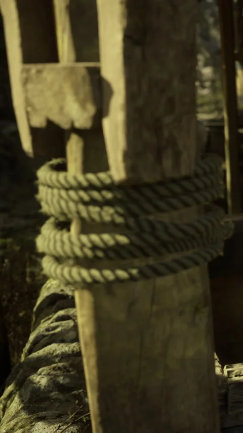 Old wooden structure with thick rope binding under warm sunlight Stock Footage 331834240