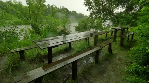 Old Wooden Tables and Benches in the Pouring Rain Tourist Base Lush Green Trees Stock Footage 64581353