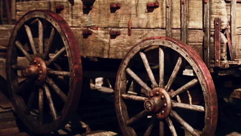 Old wooden wagon with large wheels placed in a rustic setting Video stock 345063571