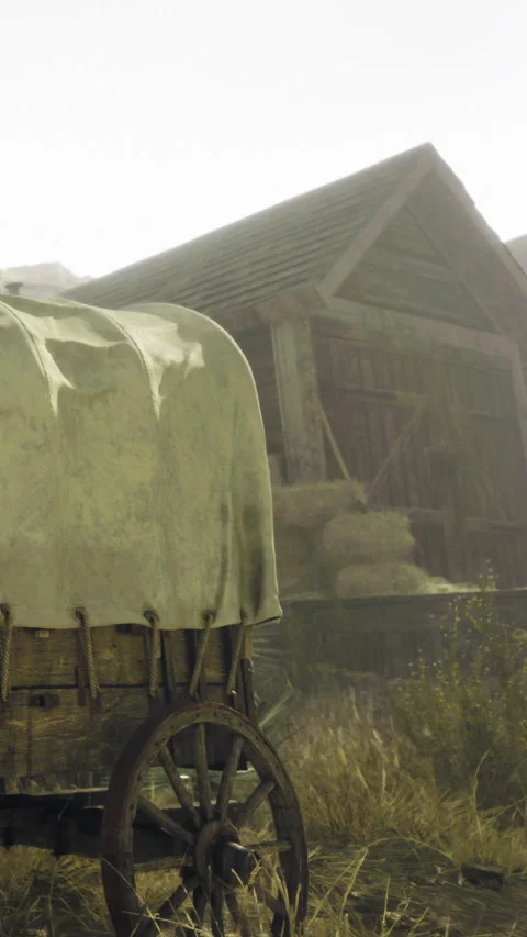 Old wooden wagon stands in front of barn during morning light in countryside Stock Footage 334106825