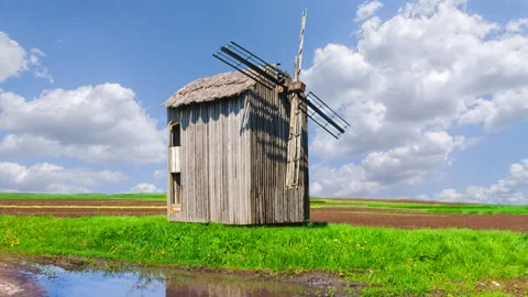 Old wooden windmill reflected in water pond time lapse scene Video stock 243376537