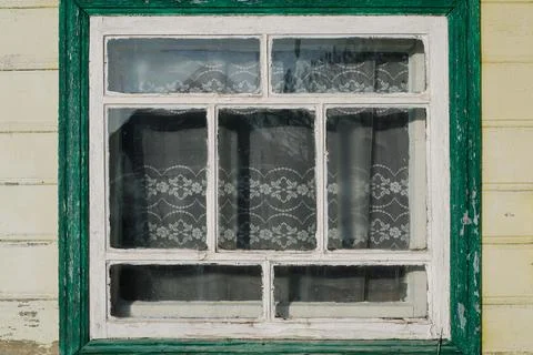 Old wooden window with peeled paint on a bright day Stock Photos