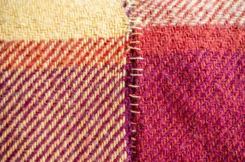Old woolen blanket torn and mended with yellow thread Stock Photos