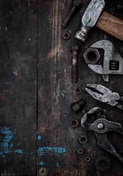 Old work tools nuts, bolts and bearings lie on a wooden workbench 写真素材