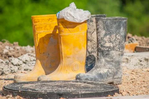 Old working rubber boots on construction site Stock Photos