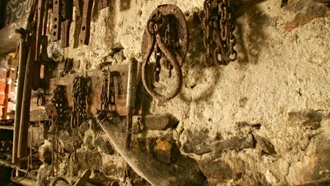 In an old workshop, blacksmith tools are on the wall. Видео 89882713