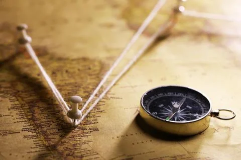 Old World Map with Compass and String Marking Travel Route Across Continents Stock Photos