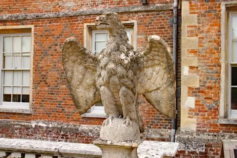An old worn and weathered eagle statue stands guard at an English country hou Stock Photos