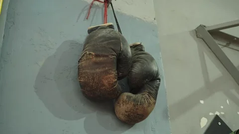 Old Worn Boxing Gloves Hanging on Gym Wall 库存影片 346539486