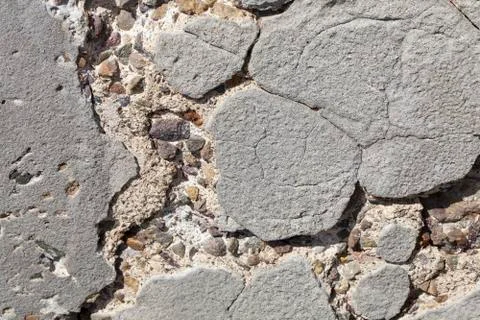 Old worn concrete wall cracking and pitted away Stock Photos