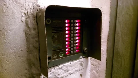 Old worn intercom with red buttons on the wall of the entrance door, background Stock Footage 297849378