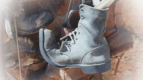 An old worn-out boot hangs as a decorative element Stock Photos