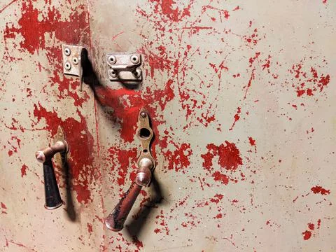 Old worn out door with broken handles and traces of red paint that resembles blo Photos