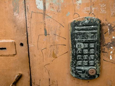 Old worn-out intercom on the iron door. Electronic lock of the entrance door Stock Photos