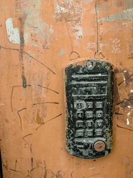 Old worn-out intercom on the iron door. Electronic lock of the entrance door Stock Photos