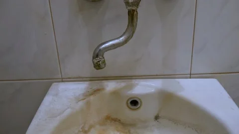 Old, worn out, leaking water tap covered with deposits of limescale and fungi Stock Footage 218173989