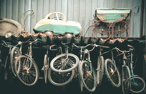 Old worn out strollers and bicycles Stock Photos