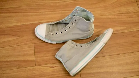 Old worn sneakers. Pair of old shoes on the floor. Retro fashioned sneakers. Stock Footage 320883923