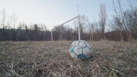 Old Worn Soccer Ball on Abandoned Overgrown Football Field with Empty Goalpost Stock Footage 331753276