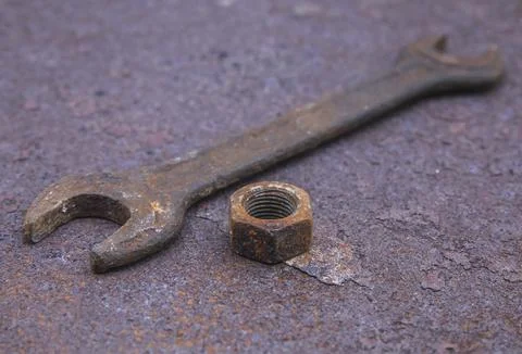 Old wrench and nut on a rusty countertop Stock Photos