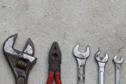 Old wrench tool with rust placed on the concrete floor background. Stock Photos