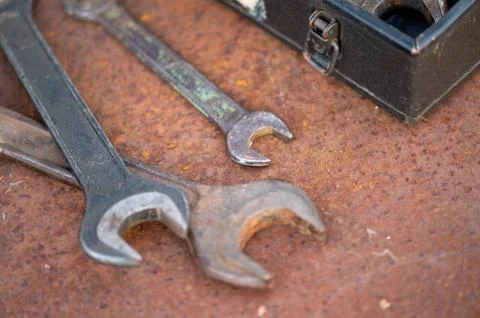 Old wrenches on a rusty sheet of metal, close-up, selective focus. Stock Photos
