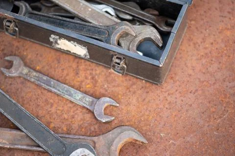 Old wrenches on a rusty sheet of metal, close-up, selective focus. Stock Photos