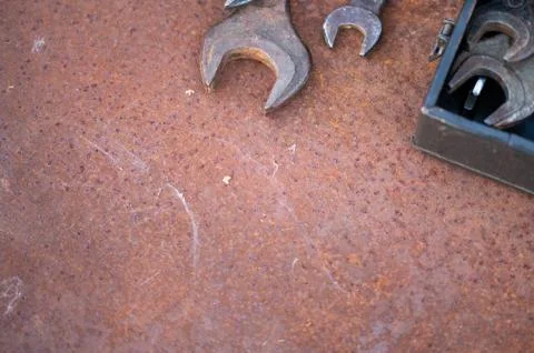 Old wrenches on a rusty sheet of metal, close-up, selective focus. Stock Photos