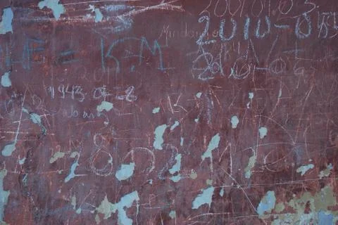 Old written wall with falling plaster stucco crumbs. Stock Photos