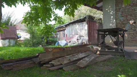 Old yard with piles of boards and metal circular saw Stock Footage 325328568