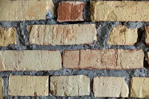 Old yellow brick wall texture background with grey concrete mortar joints Stock Photos
