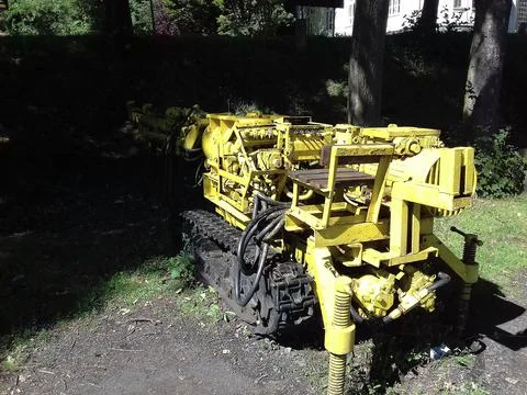 Old yellow machine used for mining coal, partly hidden in deep shadows. Stock Photos
