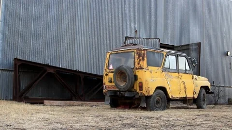 Old yellow rust SUV stands on grass Video stock 48410055