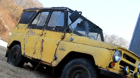 Old yellow rust SUV stands on grass Video stock 48410493