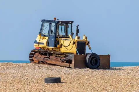 Old yellow rusting bulldozer on a seafront beach Stock-Fotos
