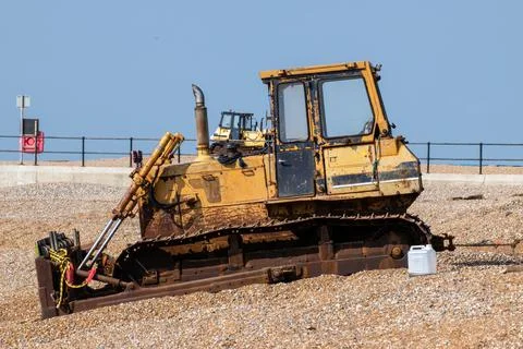 Old yellow rusting bulldozer on a seafront beach Stock Photos
