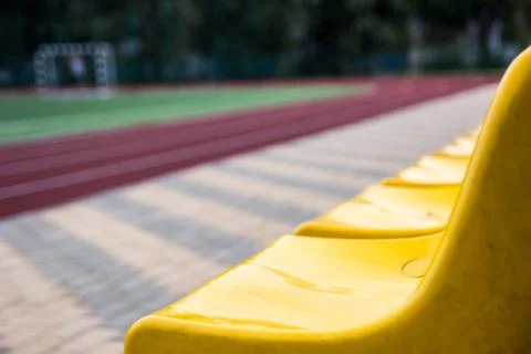 Old yellow seats in the stadium. Sport background Stock Photos