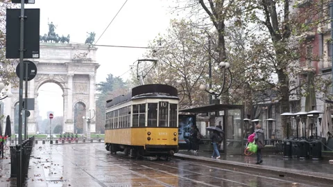Old yellow tram passes by the centre of the Old Town of Milan Arch of Peace 動画素材 165846072