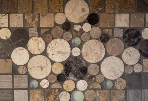 Old yellow wall with square and round ceramic tiles of different sizes and sh Stock Photos