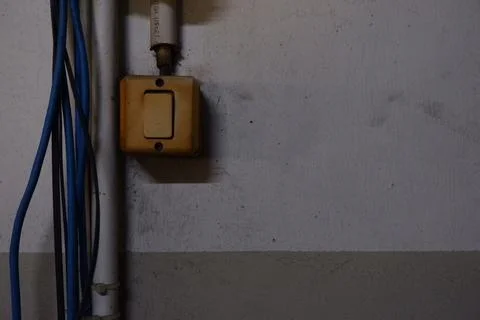 Old Yellowed Light Switch with Blue Cables on Worn Wall Stock Photos
