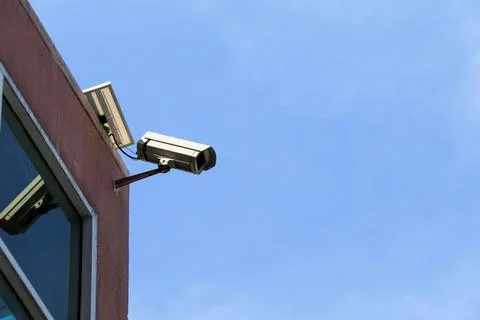 An old yet reliable CCTV camera mounted outdoors, exposed to sun and rain o.. Stock Photos