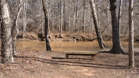 Olde Rope Mill Rd Park, GA, Wooden bench along the side of Little River Stock Footage 86981202