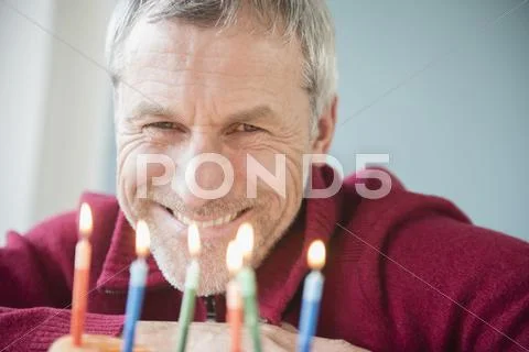 Older Caucasian Man Smiling At Birthday Cake