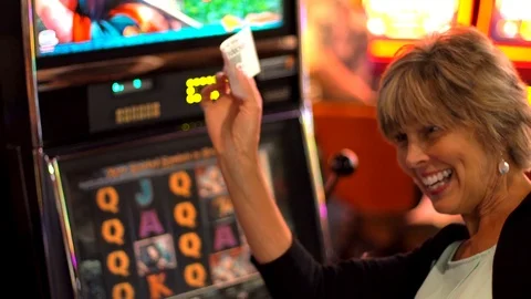 Older caucasian woman plays slot machine and wins Stock Footage