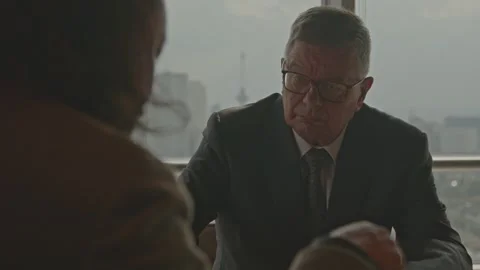 An older CEO listens to the input of one his employees while being in a Stock Footage 287612948