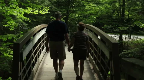 Older couple hold hands on a forest path Stock Footage 44431853